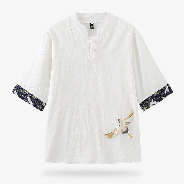 Ce t-shirt japonais est brodé avec un motif de grue Tsuru sur le tissu. Le t-shirt se ferme avec un col a bouton. La couleur du tissu est blanc et la matière est en coton et lin