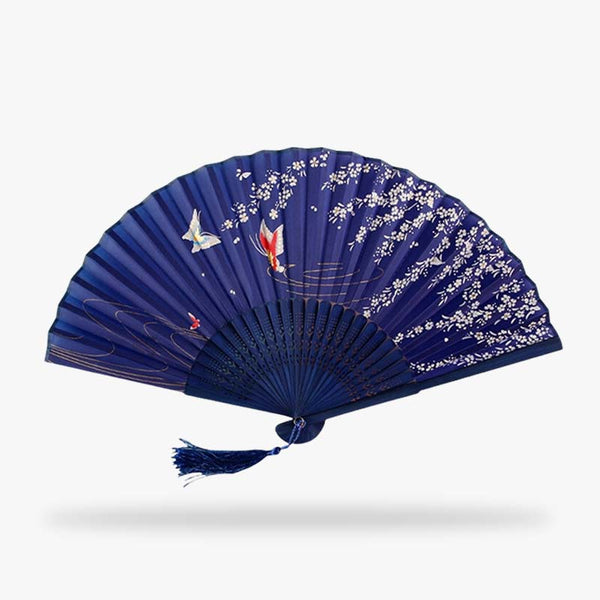 Craquez pour un de ces eventails japonais. L'accessoire est peint avec le motif sakura (cerisier japonais) et des papillons qui symbolisent la reincarnation