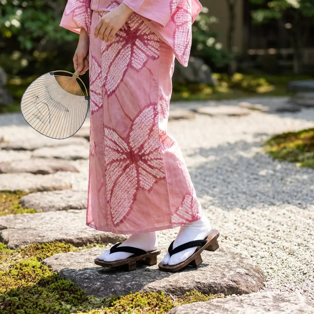 Geta Hanao Noir portées avec un kimono rose dans un jardin japonais