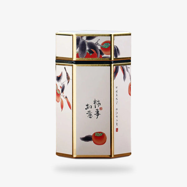 une grande boite a the metal de couleur blanche avec un kanji et des dessins de fruits et fleurs japonaises