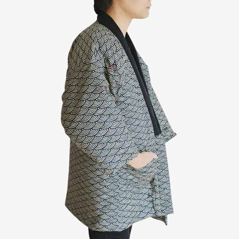 Un japonais est habillé avec un manteau hante vintage pour homme. La veste grise est molletonné. Des motifs traditionnels jaoponais sont imprimé sur le tissu du manteau kimono