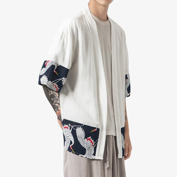 Un homme est habillé avec un kimon haori blanc. La veste japonaise est imprimée de motifs japonais Tsuru sur le tissu en coton