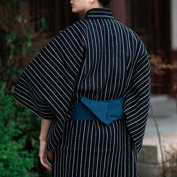 Un japonais est habillé avec un kimono coton noir homme. Le yukata japonais est attaché avec une ceinture Obi