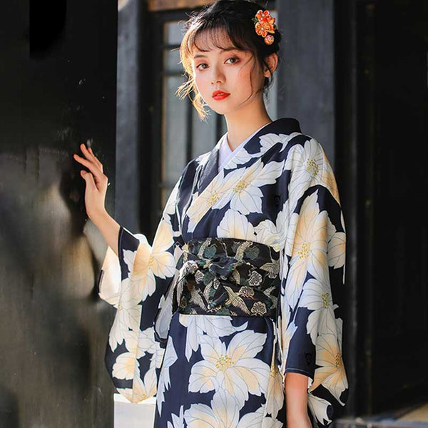 Une femme geisha est habillée avec un kimono Obi avec des motifs de fleurs japonaise et la grue Tsuru.
