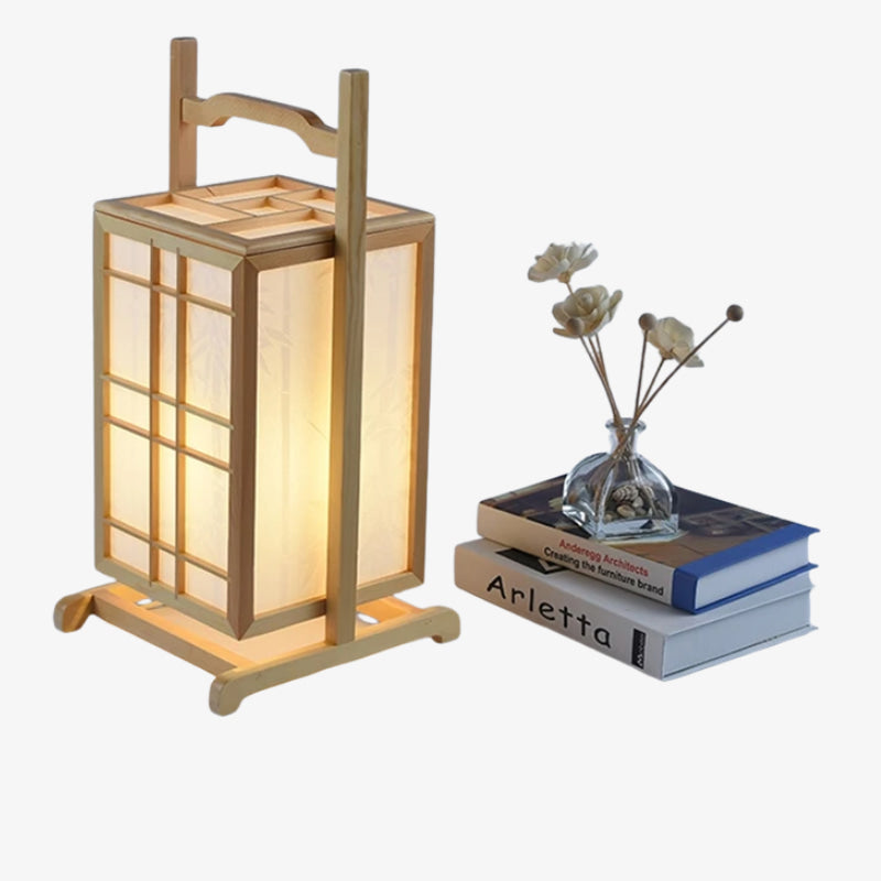 Lanterne washi traditionnelle diffusant une lumière douce près de livres et d'un petit vase de fleurs sur fond blanc