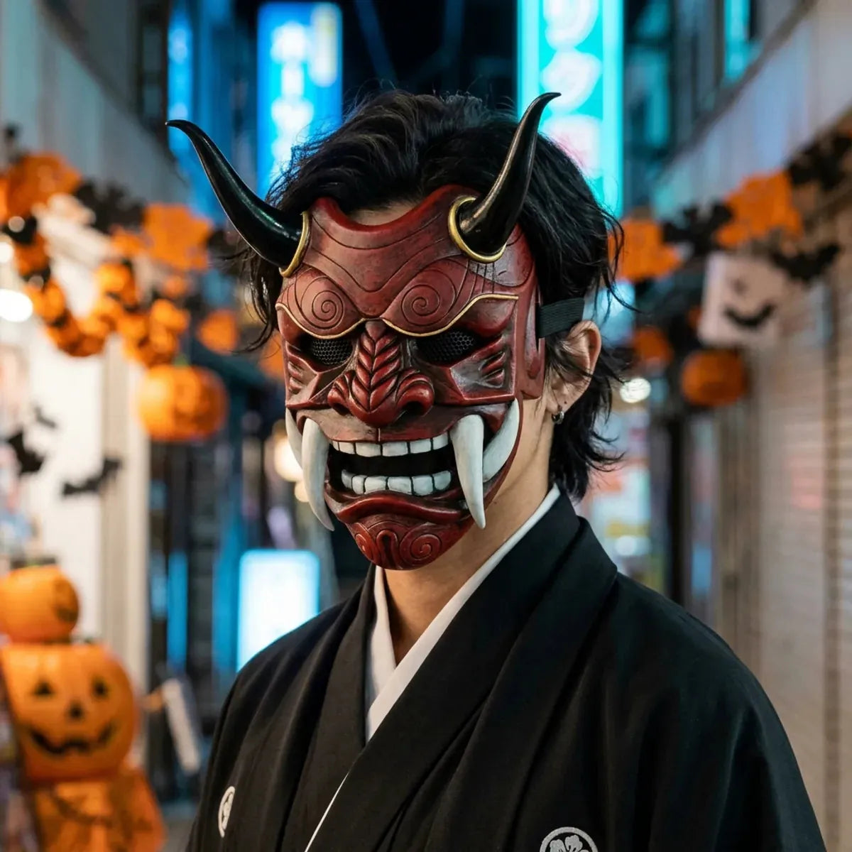 Masque oni japonais rouge à cornes porté avec un kimono noir la nuit pour Halloween, avec les néons bleus de Tokyo en arrière-plan.