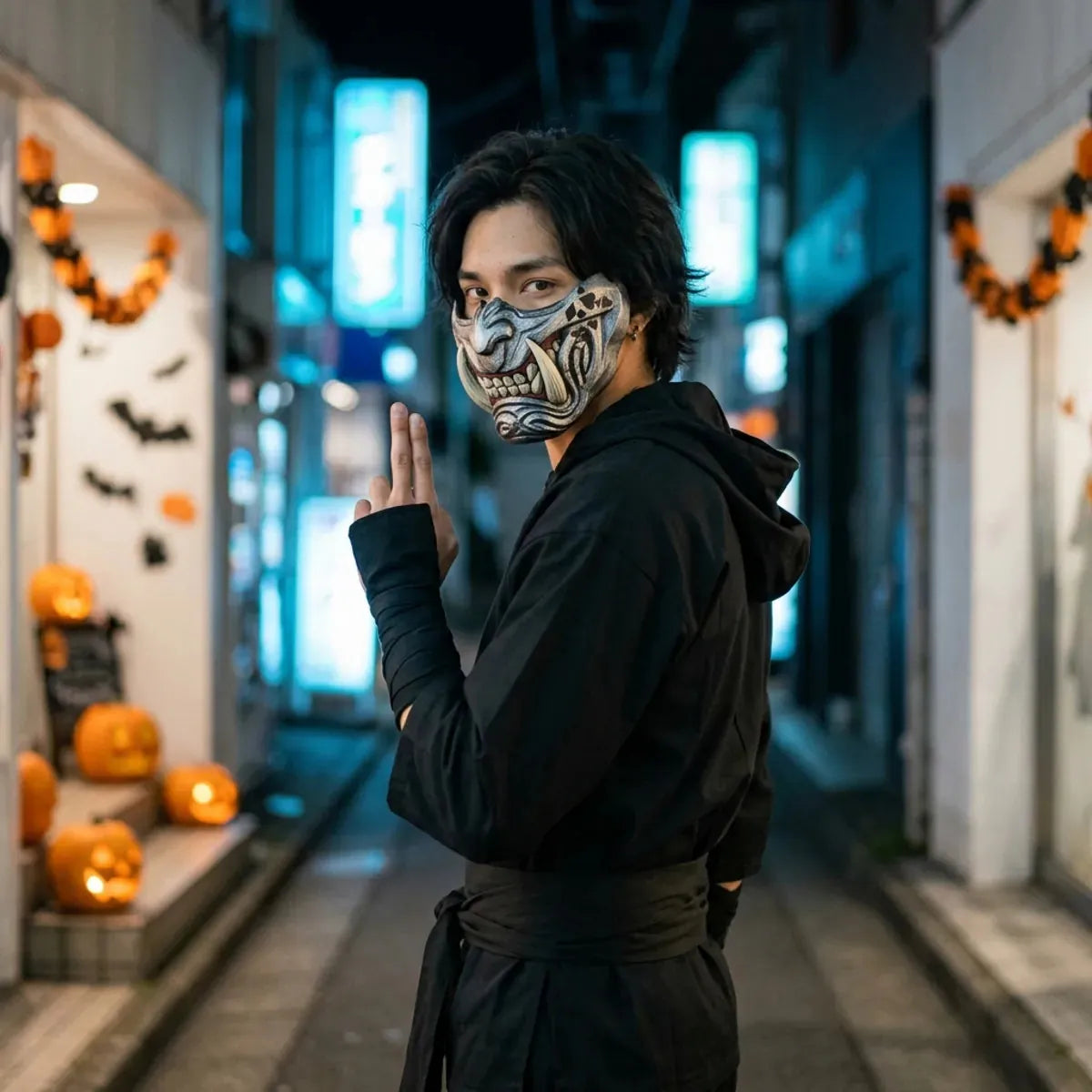 Masque oni d'Halloween porte avec une tenue de ninja noire, regard par dessus l'epaule dans une rue vide de Tokyo