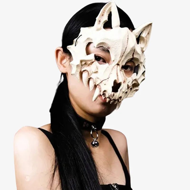 Une femme porte un masque renard japonais. Le masque de renard japonais est de couleur blanche, avec un style ossature.