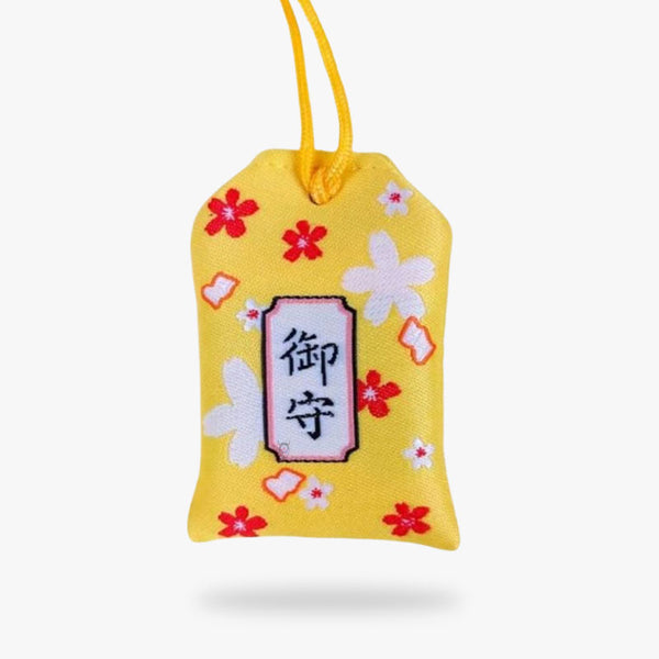 Ce porte-bonheur Omamori kanji japonais est de couleur jaune avec des motifs de fleurs de sakura