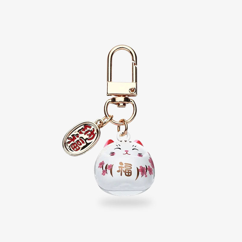 Pour attirer la chance et la richesse, voici le porte-clé maneki neko vente en masse. L'objet japonais en forme de chat kawaii est de couleur blanche avec un piècette de couleur dorée et gravée d'un kanji japonais