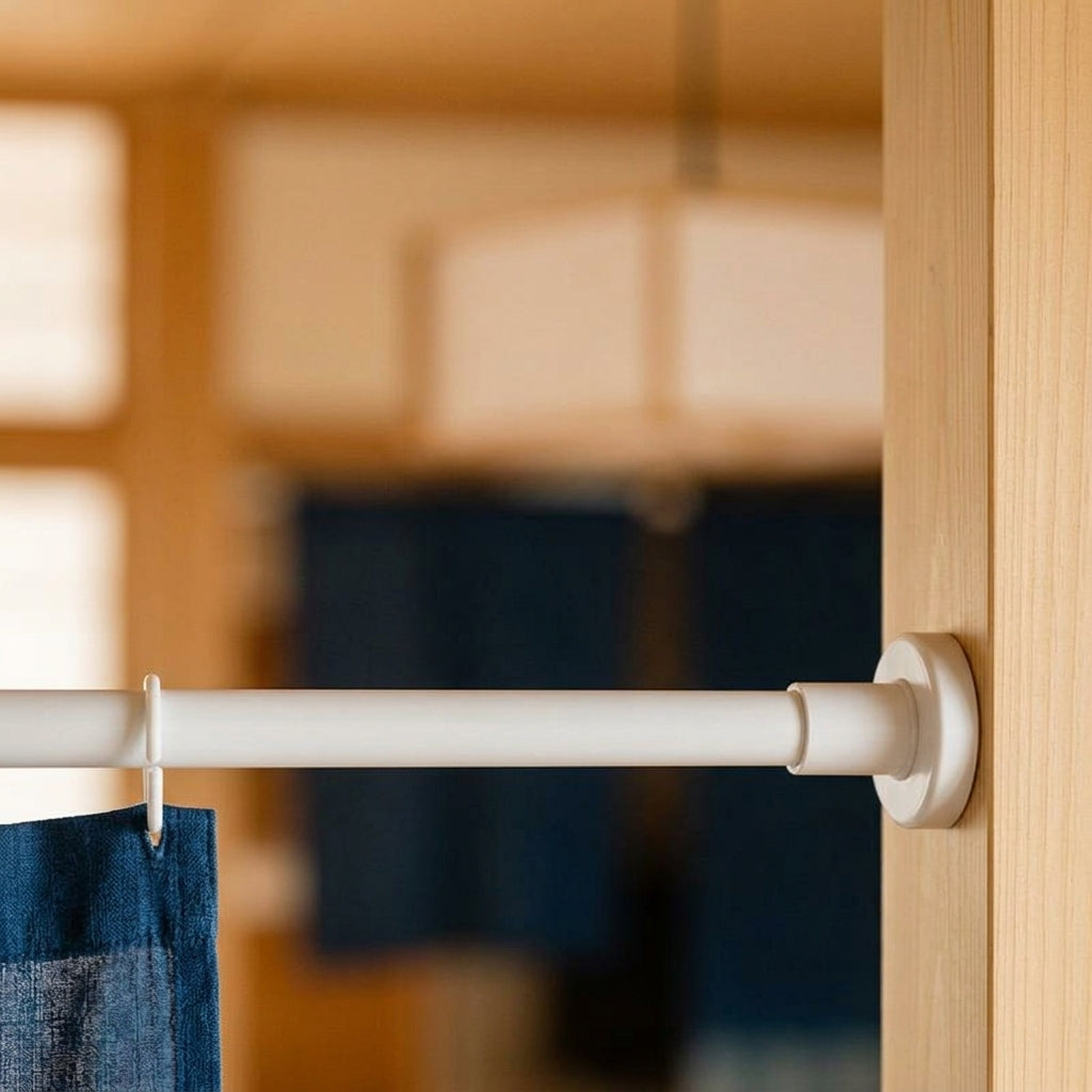 Tringle à tension soutenant un rideau noren indigo dans une embrasure en bois