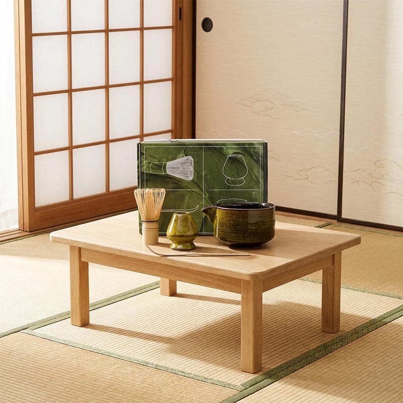 Service à thé japonais doré posé sur une table en bois dans une pièce tatami