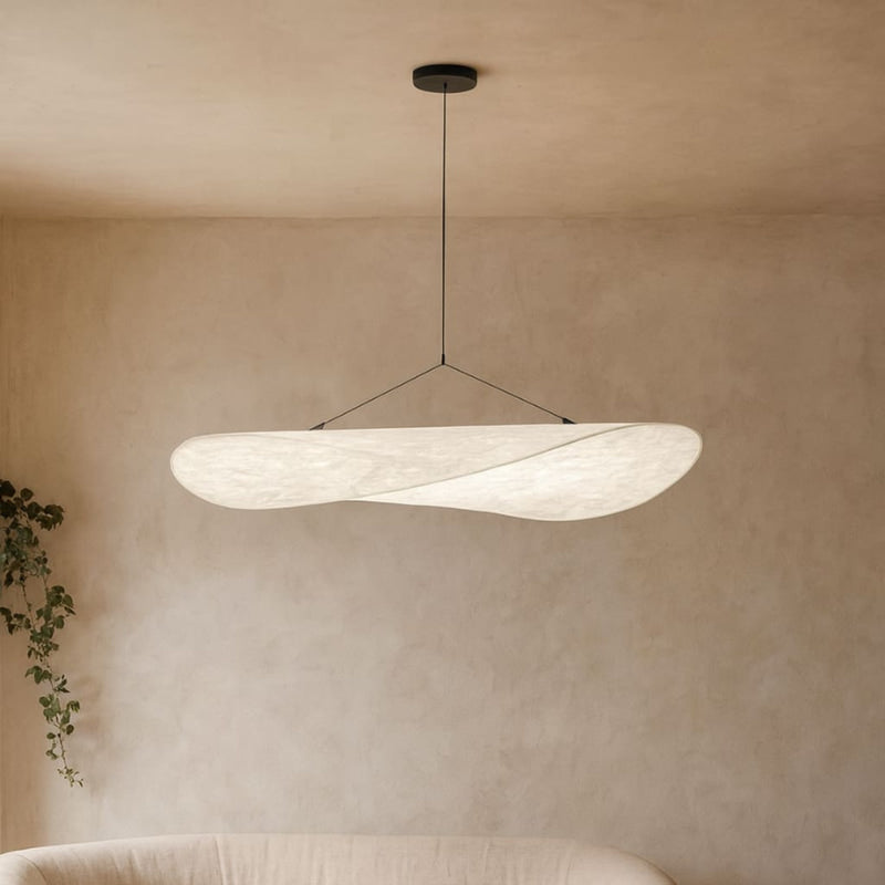 Suspension japonaise en papier washi suspendue dans un salon aux murs neutres avec une plante