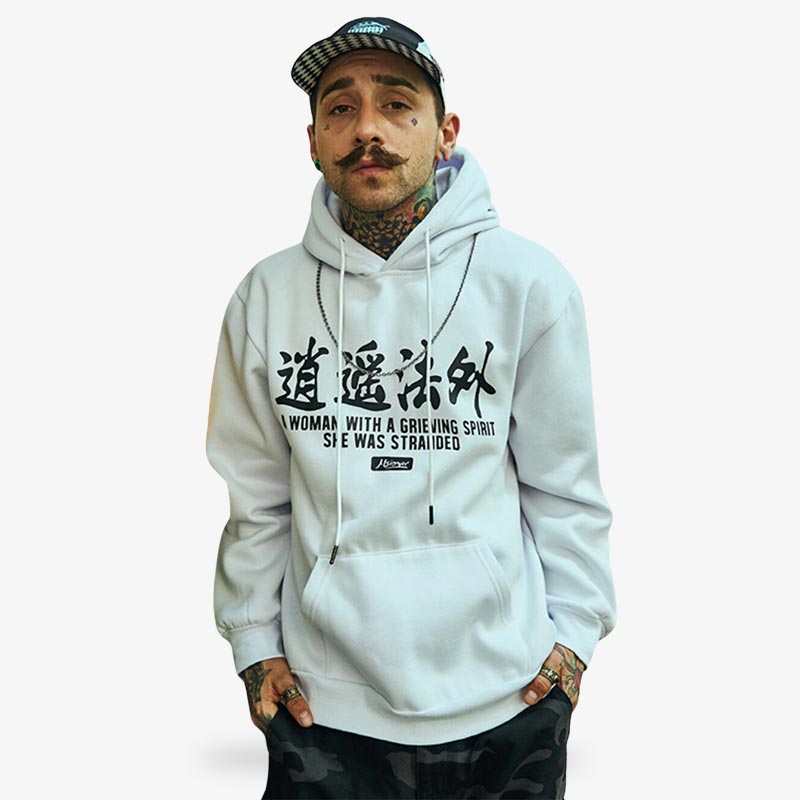 Un homme porte un sweat à capuche japonais blanc avec des kanji noirs imprimés