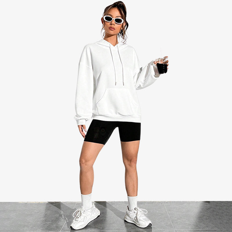 une femme japonaise porte un Sweat à capuche blanc orné d’une impression artistique de la Vague japonaise de Kanagawa dans le dos, fusionnant l’héritage culturel et le streetwear japonais.