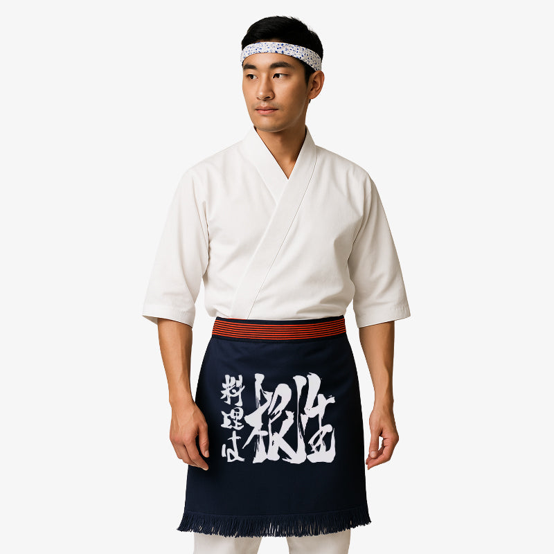 Tablier maekake traditionnel en coton épais bleu marine, orné d'un kanji blanc symbole d'authenticité et d'héritage culturel dans l'art culinaire japonais.