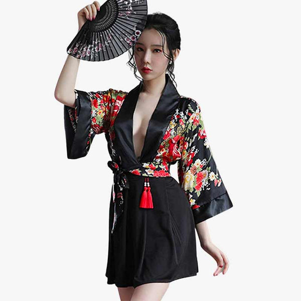 Une geisha japonaise porte un kimono de nuit femme de couleur noir, et elle tient un eventail sensu dans sa main