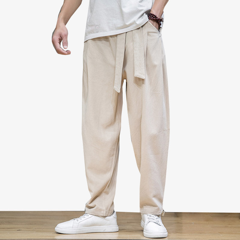 Un homme porte un pantalon large style japonais avec une ceinture Obi autour de la taille