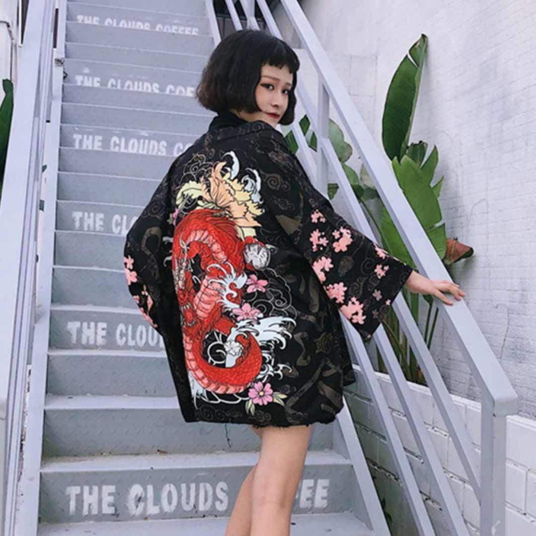 Une fille japonaise porte une veste kimono pour femme avec un motif de dragon japonais rouge et des fleurs de Sakura