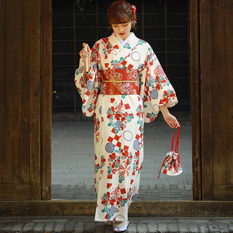 Une femme japonaise est vêtue d'une ceinture kimono rouge. Elle porte aux pieds des claquettes japonaises Geta. Elle tient dans la main un sac Kinchaku. C'est un sac japonais de kimono. Le kimono japonais est imprimés de motif géométriques