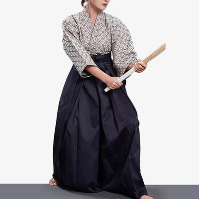 Une femme est habillée avec un Hakama pants de couleur bleu. C'est une tenue d'entrainement aux arts martiaux japonais