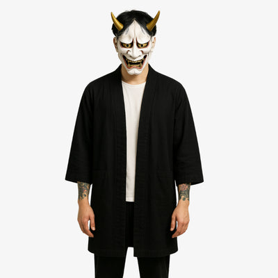 Veste haori kimono noir pour homme à la silhouette minimaliste et fluide, idéale pour un look japonais raffiné et discret. L'homme porte un masque hannya blanc.