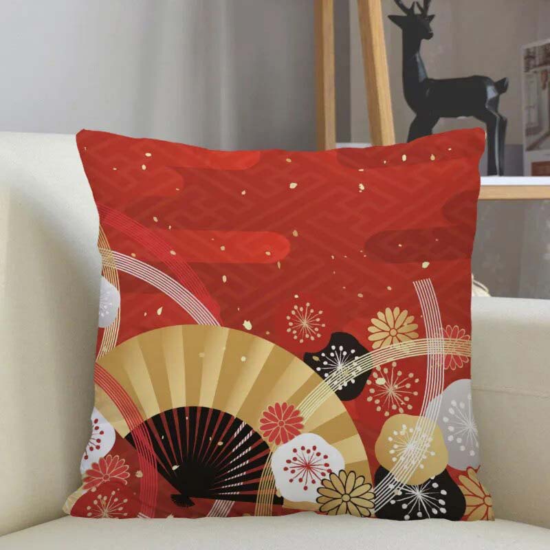 Un coussin japonais Noel  couleur rouge avec des motifs d'éventails est posé sur un canapé blanc