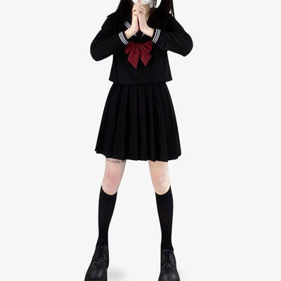 Japon uniforme scolaire noir composé d’un sailor fuku avec chemise à manches longues, jupe plissée et ruban marin noir, porté par les étudiantes japonaises.