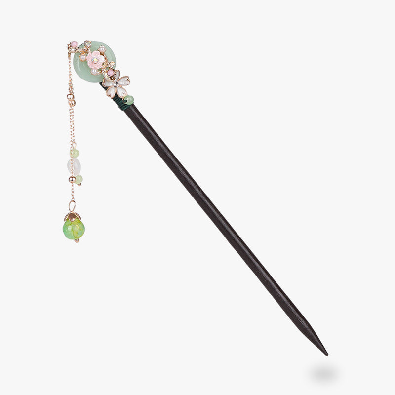 Un pic a cheveux Kanzashi sakura avec des fleurs de cerisiers incrusté sur le bois du stick. Des perles du bijou pour cheveux pendent à l'extrémité du bijou au bout d'une chaine 