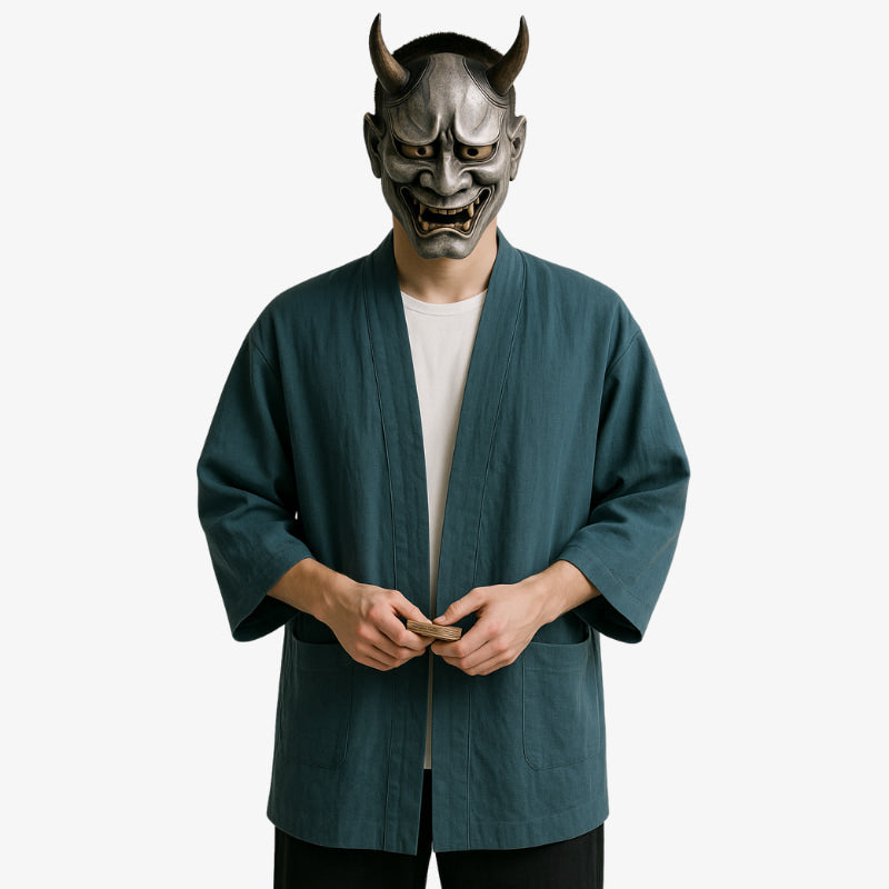 Une personne debout sur un fond blanc, il porte un Kimono Cardigan Homme, d'une élégante simplicité, alliant tradition et style urbain. Un masque japonais hannya gris fait main dissimule son visage.