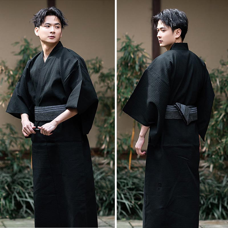 La meme personne est habillée avec un kimono japonais homme couleur noir. Le yukata est attaché avec une ceinture Obi grise