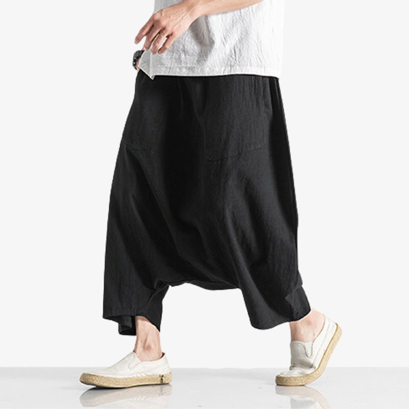 Un homme marche avec un pantalon japonais Mompe. C'est un pantacourt japonais de couleur noir