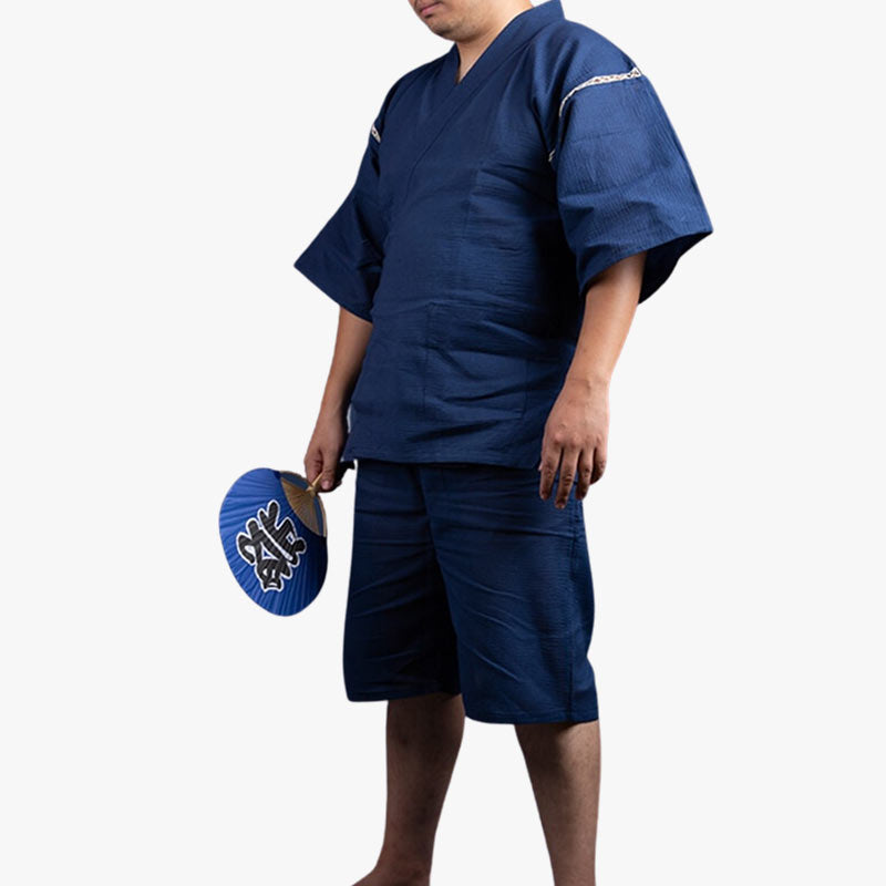 Ce Jinbei traditionnel est un pyjamas homme japonais. L'eventail Uchiwa dans la main a un kanji imprimé sur le tissus