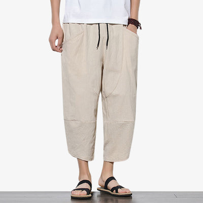 Un pantacourt japonais de couleur beige. L'homme a des sandales japonaises en bois sur ses pieds