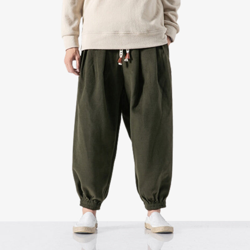 un homme porte un pantalon japonais cargo de couleur marron. Ce vêtement japonais a un cordon imprimé avec des kanji