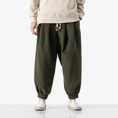 un homme porte un pantalon japonais cargo de couleur marron. Ce vêtement japonais a un cordon imprimé avec des kanji
