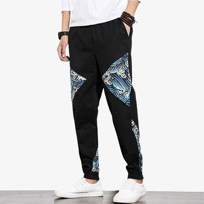 Un homme est habillé avec un pantalon slim japonais. Le pantalon japonais a des vagues brodées sur le tissu en coton noir