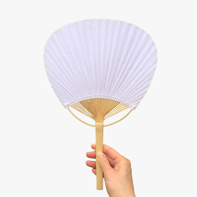 Ou acheterd des Uchiwa eventail japonais. Une femme tient un eventail rond japonais dans la main acheté sur le site Shogun-Japon