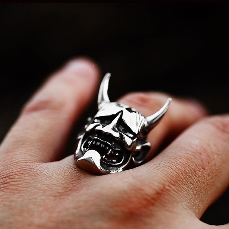 Un homme porte au doigt une bague hannya. Le bijou est une tête de démon Oni