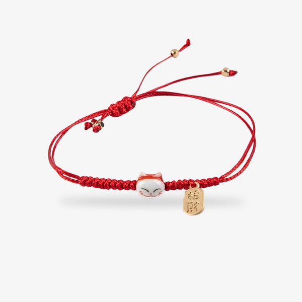 Ce bracelet maneki neko est de couleur rouge avec une tete de chat japonais et une piécette gravée avec un kanji couleur or