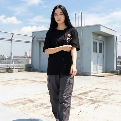 Détail de la broderie fleur de cerisier sur t-shirt noir