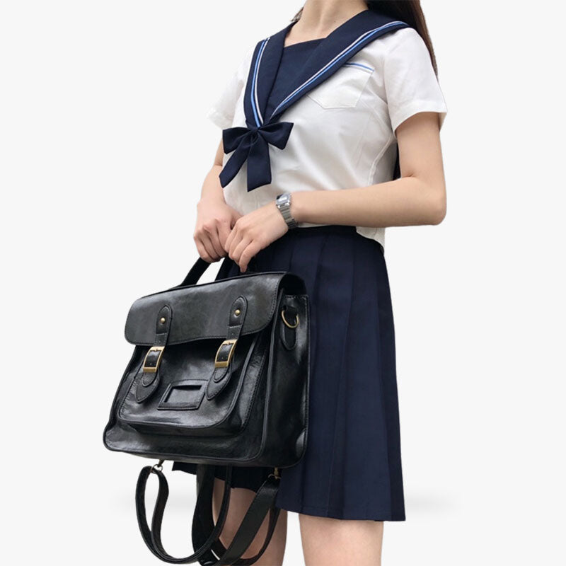 Une femme porte un cartable d'etudiante japonaise. Elle est habillée avec un uniforme japonais sailor fuku
