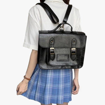 Une etudiante porte dans le dos un cartable japonais noir. Elle est habillée avec un sailor fuku. L'uniforme japonais des étudiantes japonaises. Le sac japonais vintage est en matière cuir