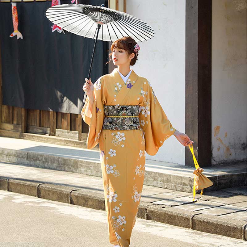 Une japonaise est vêtue d'un kimono japonais à fleur et d'une ceinture femme style obi