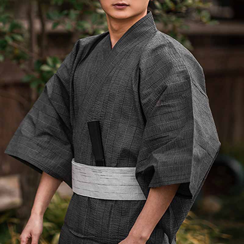 Un homme est vêtu d'un kimono traditionnel attaché avec une ceinture japonaise blanche