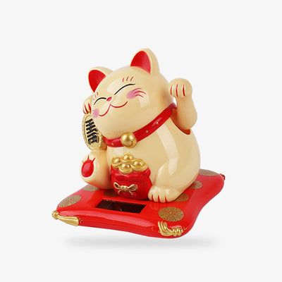 Ce chat maneki neko est de couleur jaune. Il attire la chance avec sa patte gauche levée. Il tient dans sa patte droite une pièce Koban