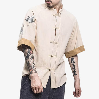 Homme portant une chemise japonaise traditionnelle avec motif tsuru symbolique dans un style casual moderne, parfaite pour exprimer ses racines culturelles. La chemise crème en coton et lin se ferme par des boutons sur ses manches courtes