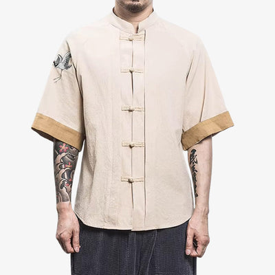 Homme portant une chemise Tsuru avec des motifs de grue (tsuru) brodés sur coton couleur crème, symbolisant la longévité et la paix dans la culture japonaise, rendus dans une forme graphique élégante