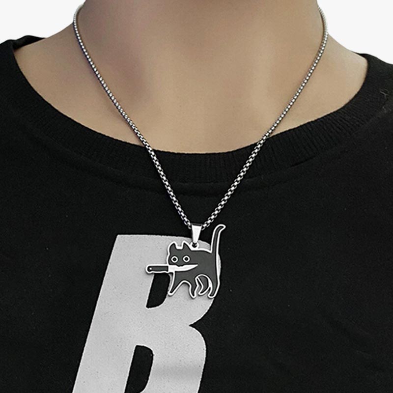 Un femme porte un collier animal kawaii avec un pull noir et une chaine en argent