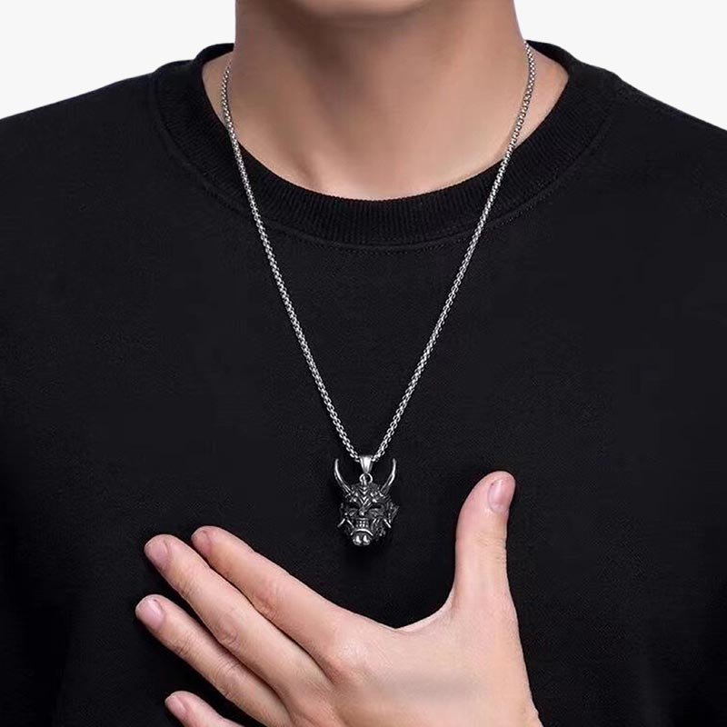 Un homme porte autour du cou un collier traditionnel japonais avec un pendentif de démon